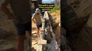 Stonemason places the final stones in a wall mason stonemason retainingwalls [upl. by Tresa110]