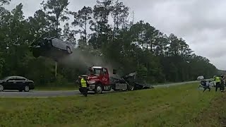 Driver sends car flying off parked tow truck ramp in front of police  Body cam [upl. by Enilaf624]