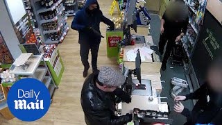 Robbers who threaten shop staff with gun caught on CCTV  Daily Mail [upl. by Ailemaj]