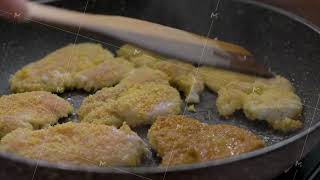 In pan breaded chicken pieces are cooked and flipped with spatula until golden brown [upl. by Eirrot237]