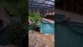 This backyard has a huge grotto a waterslide a big spa a swimup bar a screened enclosure [upl. by Enaerb353]