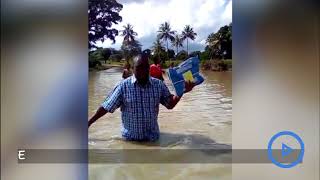 Kirewe secondary principal wades through a flooded river to deliver exam materials [upl. by Pickens536]