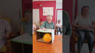 Players push long pins through a cardboard box attempting to pop the balloon [upl. by Griffiths531]